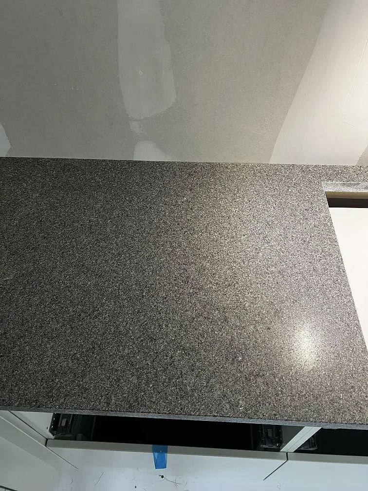 Yta i matt Bohus Grå granit med hälluttag under montering i köket i Lerum.