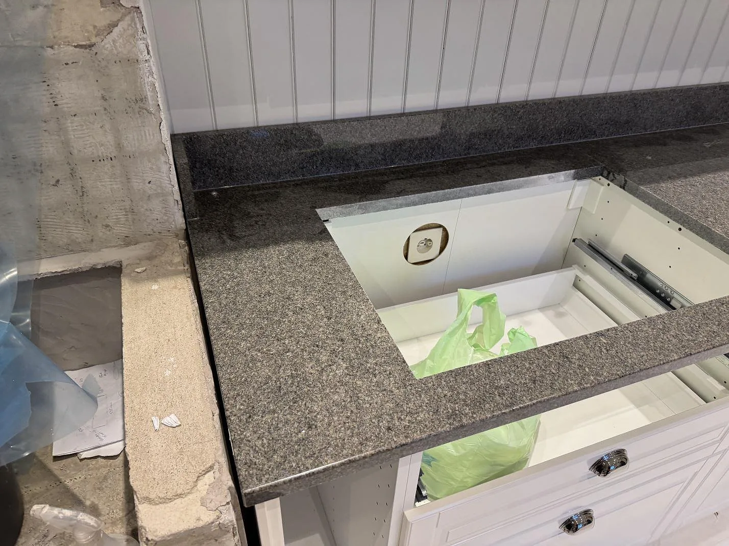 Närbild av polerad köksbänkskiva i Bohus Grå granit med öppet urtag och stänkkant under montering i Säffle.