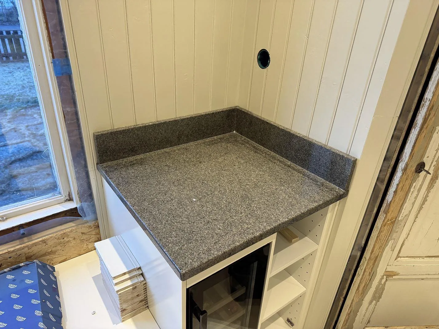 Mindre köksbänkskiva i polerad Bohus Grå granit med låg stänkkant på vit inredning i Säffle.