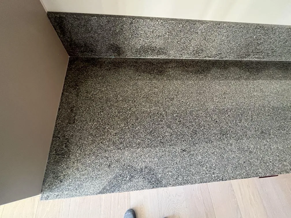 Arbetsbänk i polerad Bohus Grå granit med uppvikt stänkskydd mot vägg i kök i Stockholm.