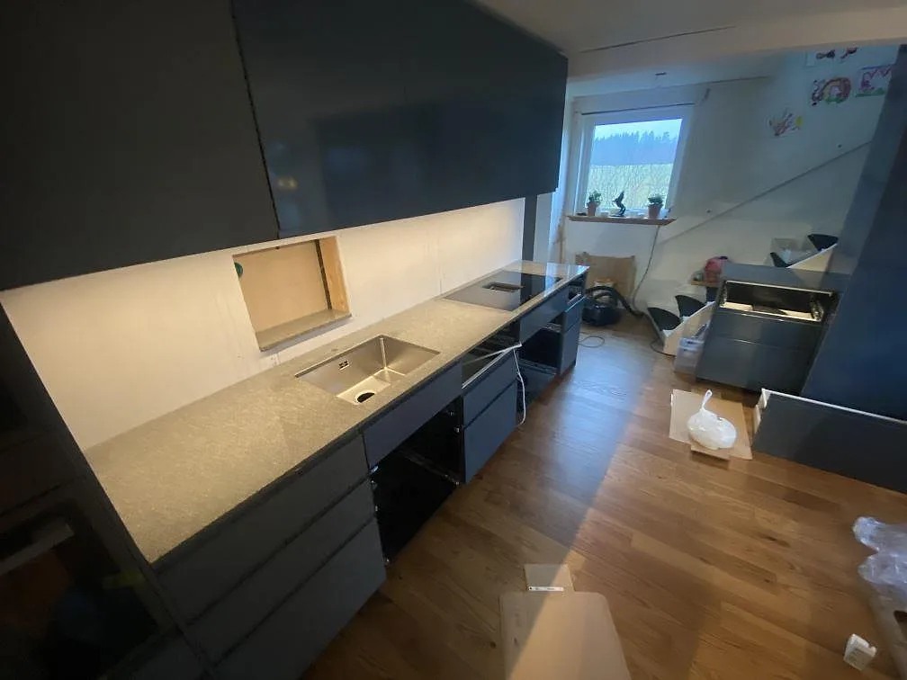 Köksbänkskiva i grå Bohus Grå granit med underlimmad diskho och infälld induktionshäll, mitt under montering