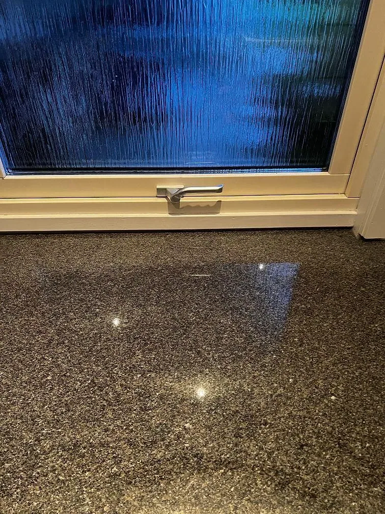 Detalj av blank polerad Bohus Grå granit med fönsterreflex på köksbänkskiva i Växjö.