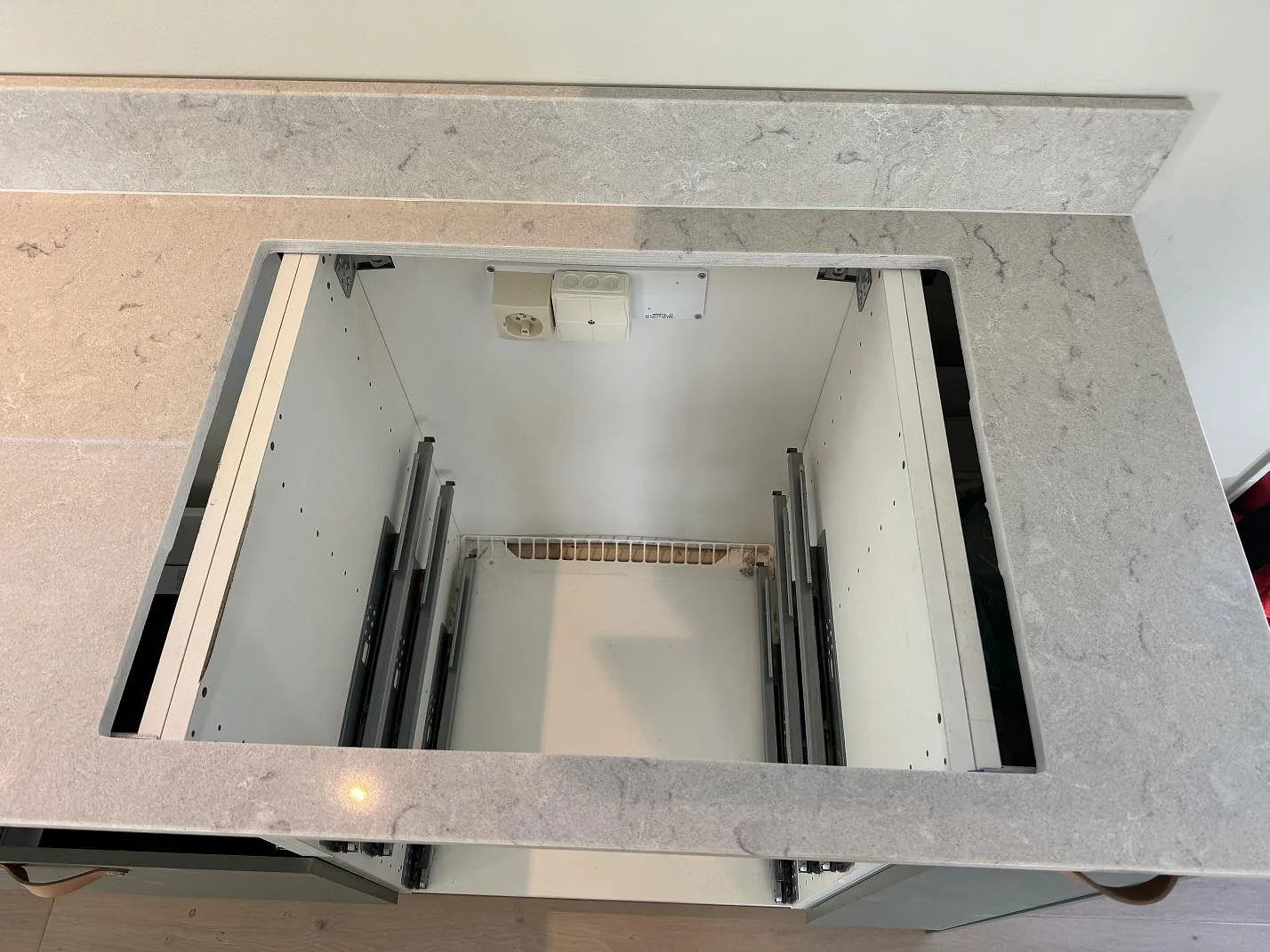 Topvy av hällöppning i polerad Caesarstone Bianco Drift med ljusgrå komposityta i Åsa.