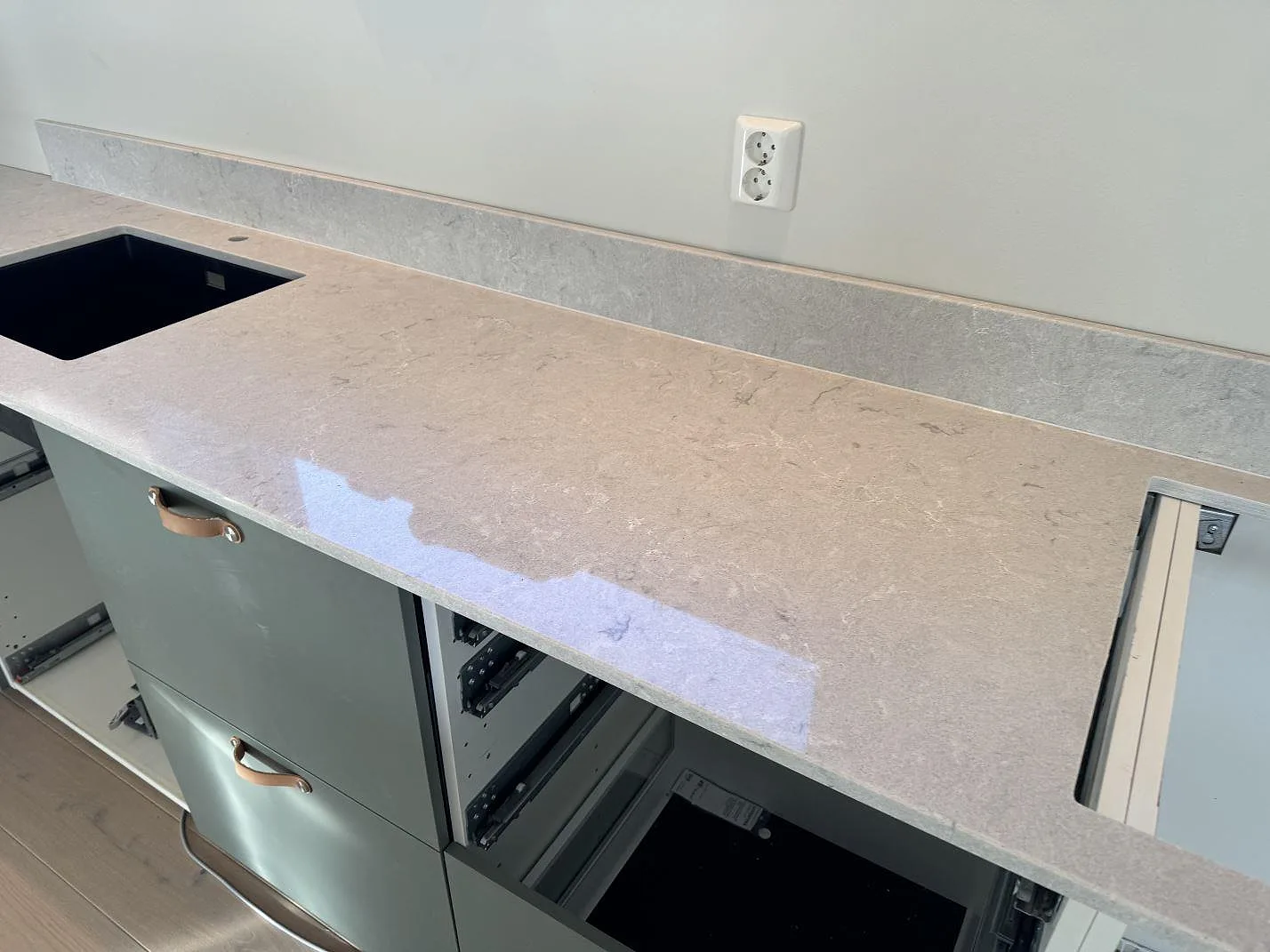 Perimeterbänk i polerad Caesarstone Bianco Drift med svart diskho, hällöppning och stänkkant i Åsa.