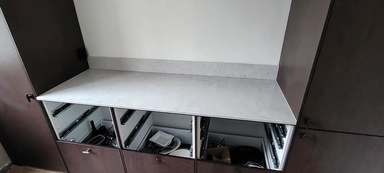Rak bänkskivedel i polerad Caesarstone Bianco Drift med ljus ådring och låg stänkkant mot mörka köksstommar i Johanneshov.