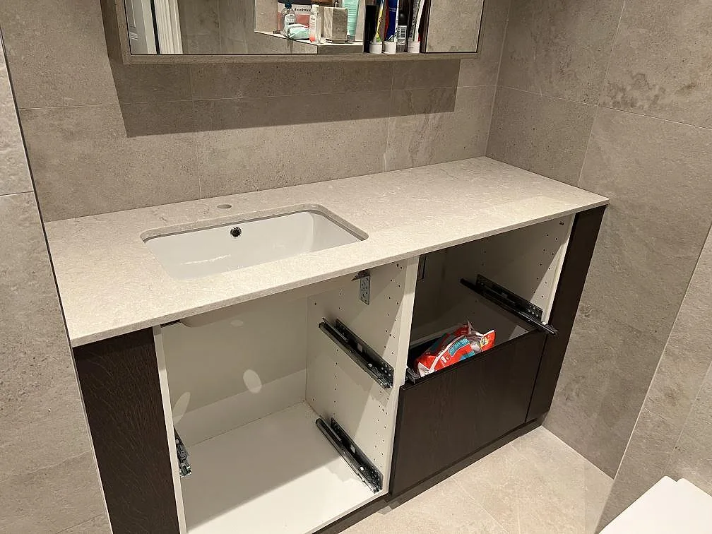 Badrumsbänkskiva i polerad Caesarstone Bianco Drift, ljus komposit, med vitt tvättställ i Stockholm.