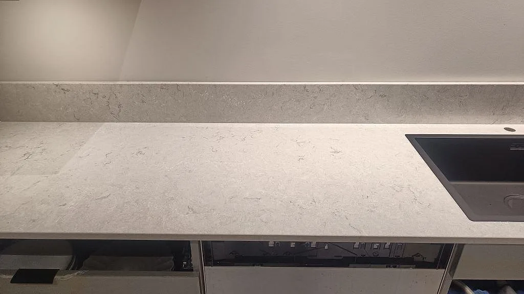 Rak köksbänkskiva i polerad Caesarstone Bianco Drift med diskho och stänkkant i Tidaholm.