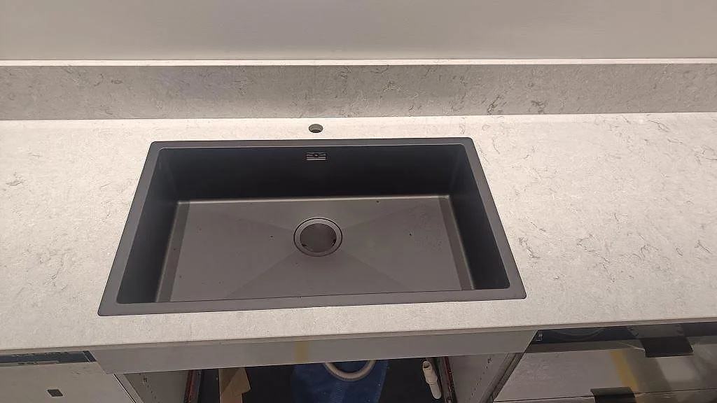 Underlimmad diskho i en polerad Caesarstone Bianco Drift bänkskiva med låg stänkkant i Tidaholm.