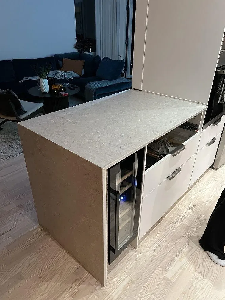 Köksödel med polerad Caesarstone Bianco Drift i ljus kvartskomposit i ett kök i Uppsala under montering.