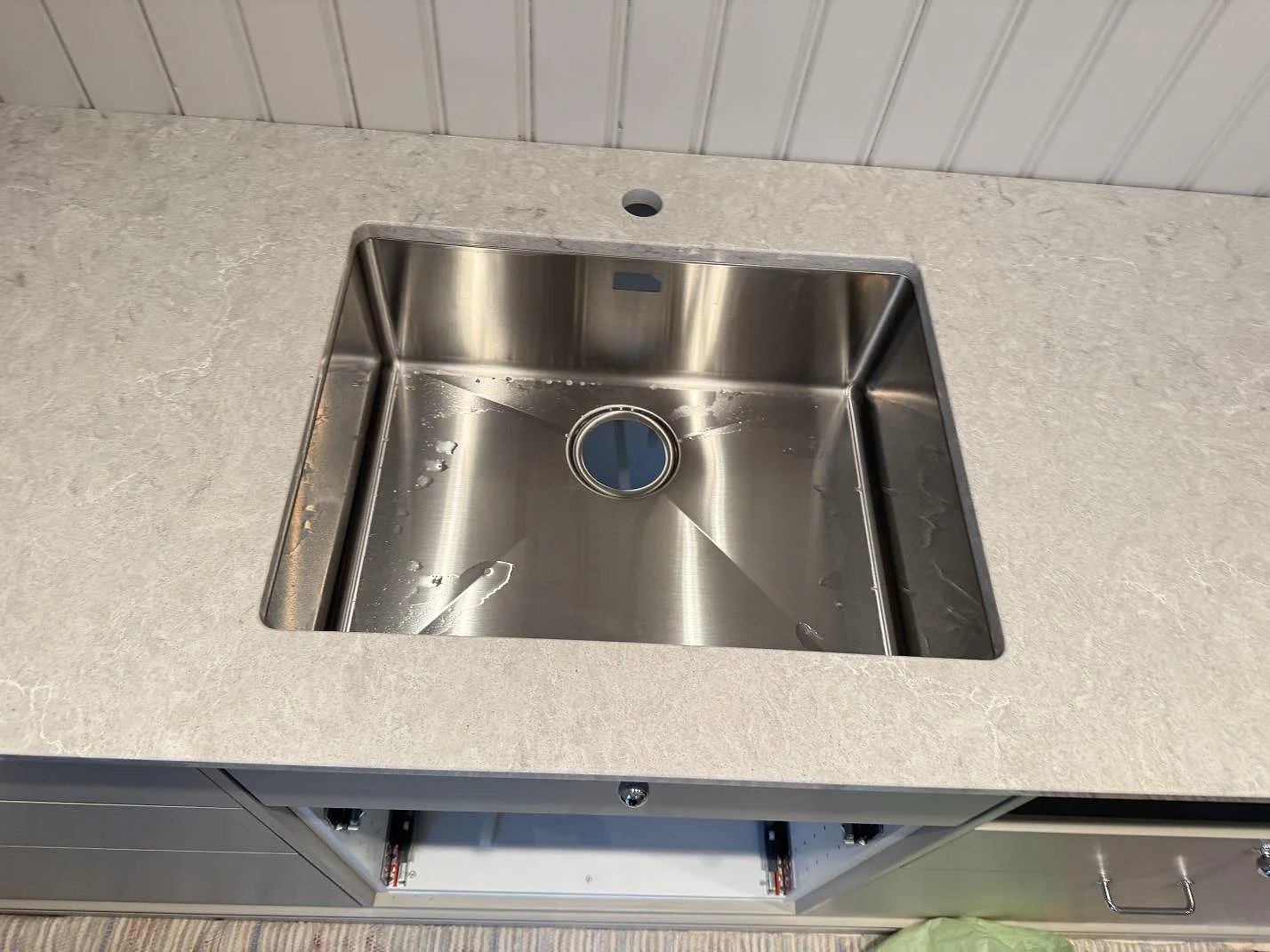 Rostfri diskho i en polerad Caesarstone Bianco Drift bänkskiva med ljus kompositådring i Vårgårda.