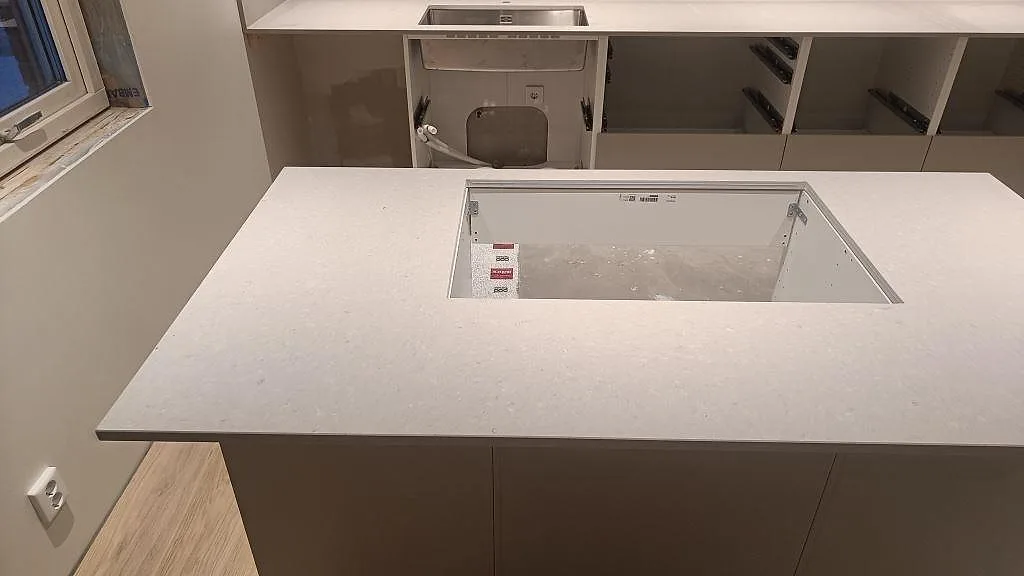 Närbild av köksö med matt Caesarstone Clamshell i 20 mm och utskärning för häll i Åseda.