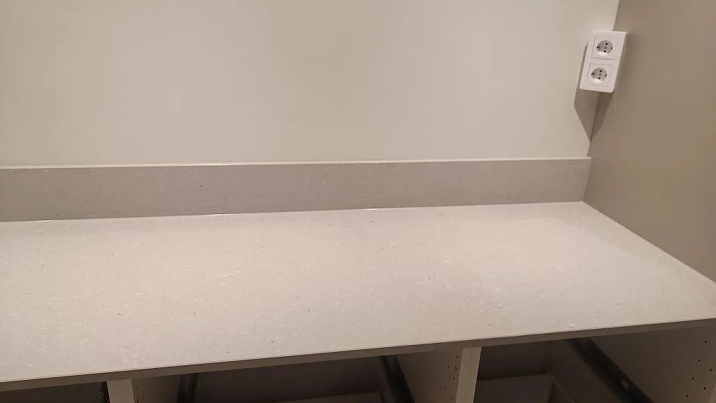 Detalj av matt Caesarstone Clamshell med låg stänkkant och ljus komposityta i kök i Åseda.