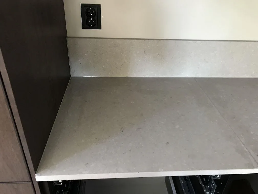 Köksbänkskiva i beige Caesarstone Clamshell med uppvikt stänkkant mot vägg i ett kök i Göteborg.