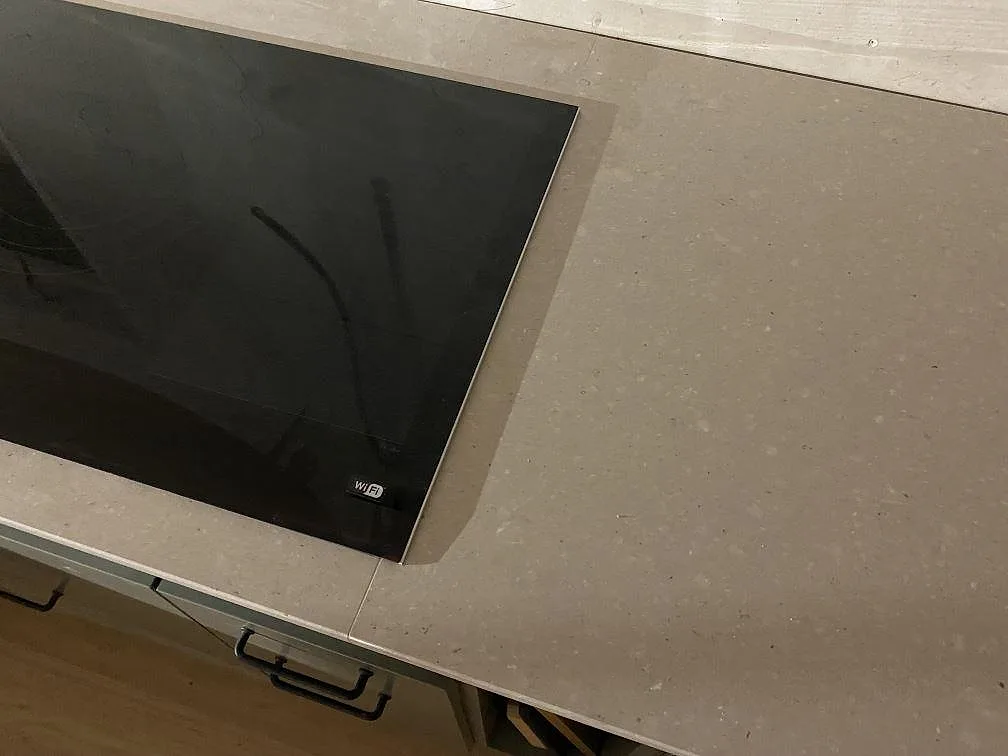 Detalj av hällzon i matt Caesarstone Clamshell, 20 mm ljusgrå kvartskomposit i ett kök i Lerum.