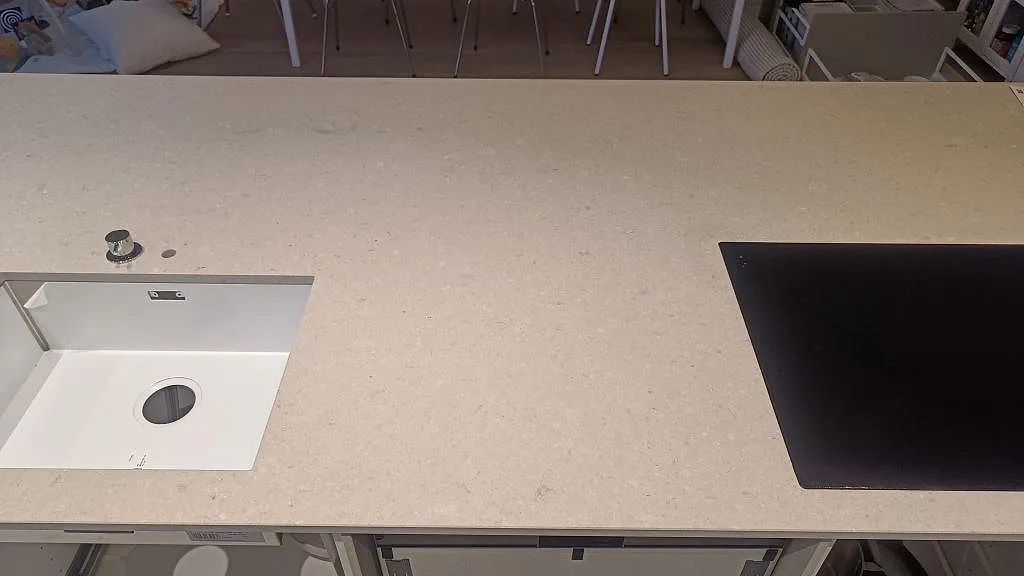 Matt Caesarstone Clamshell som köksbänkskiva med vit ho och svart häll i ett kök i Lomma.