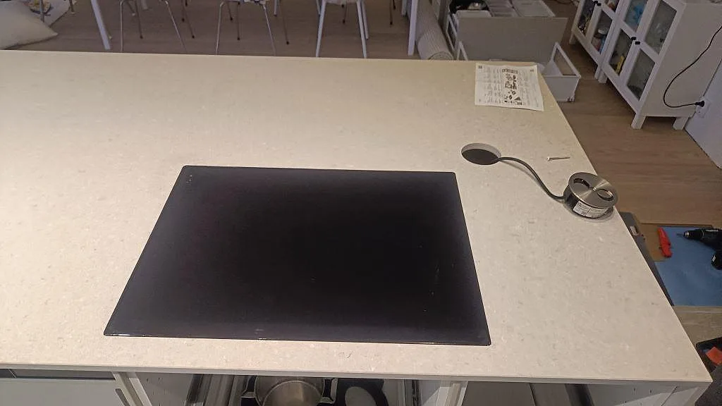 Köksbänkskiva i matt Caesarstone Clamshell med svart häll och installationsdetaljer i Lomma.