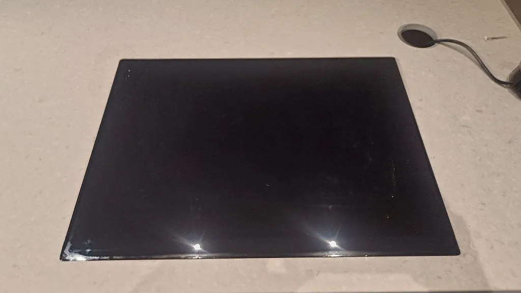 Detalj av svart häll placerad i matt Caesarstone Clamshell på köksbänkskiva i Lomma.