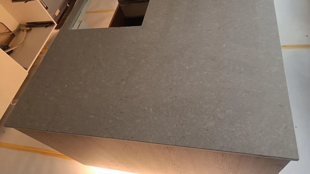 Närbild av köksö i polerad Caesarstone Clamshell komposit med rektangulärt hälluttag i ett kök i Malmö.