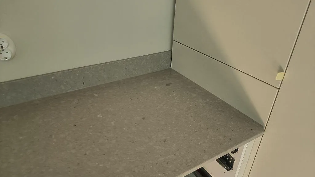 Väggbänk i polerad Caesarstone Clamshell komposit med låg uppvikt stänkkant och vita stommar i Malmö.