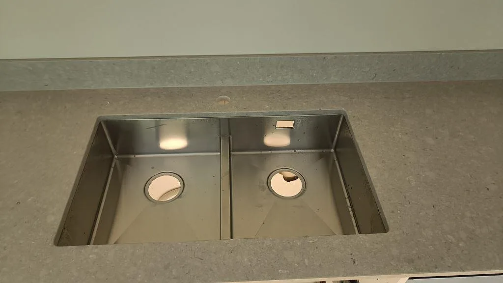Dubbel underlimmad rostfri diskho i en polerad Caesarstone Clamshell bänkskiva med låg stänkkant i Malmö.