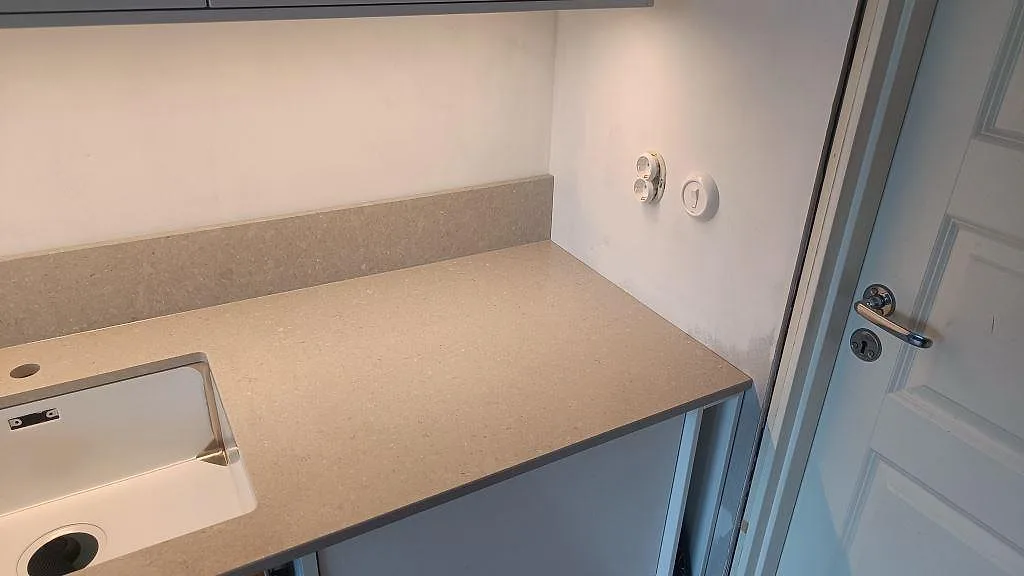 Höger del av köksbänken i Caesarstone Clamshell med polerad yta, uppvikt stänkkant och diskho i Malmö.