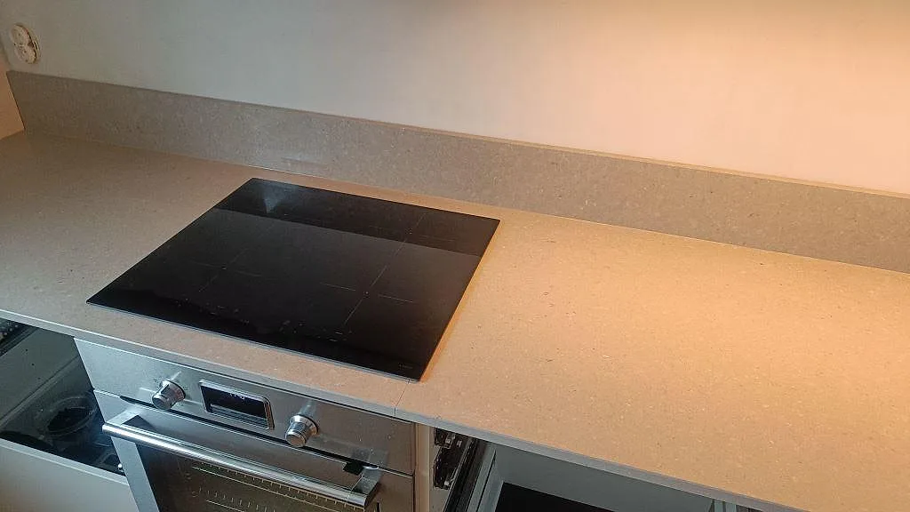 Induktionshäll monterad i polerad Caesarstone Clamshell kompositbänkskiva med låg stänkkant i ett kök i Malmö.