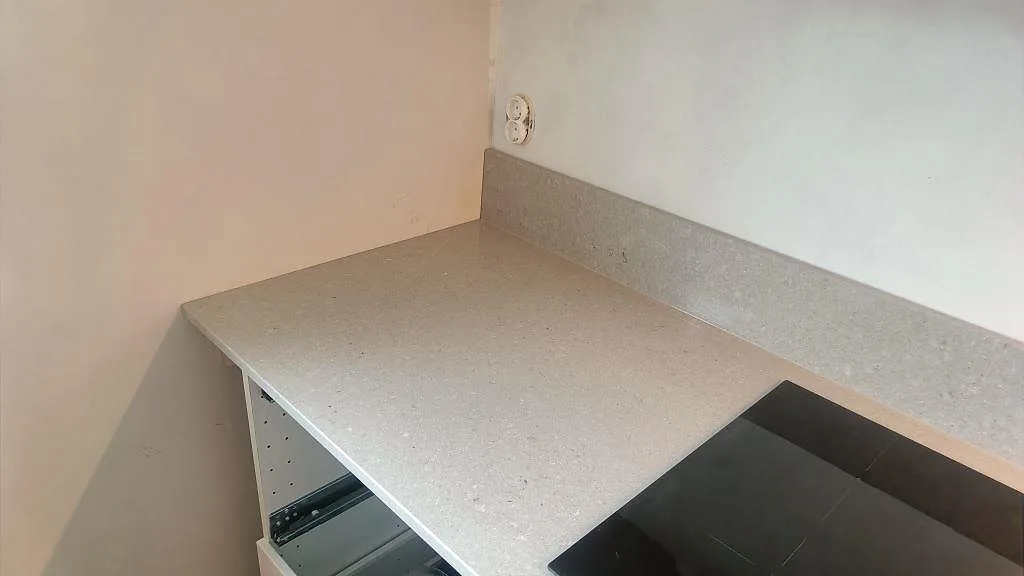 Hörnvy av Caesarstone Clamshell köksbänkskiva med polerad komposityta och induktionshäll i Malmö.