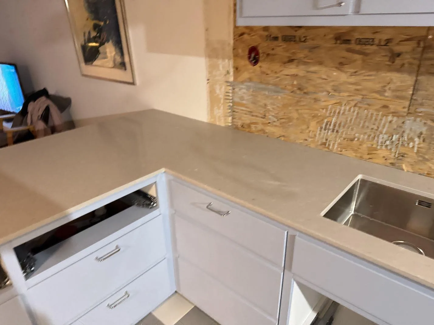 Köksbänkskiva i Caesarstone Clamshell, polerad kvartskomposit, med rostfri diskho och öppen köksstomme i Malmö.