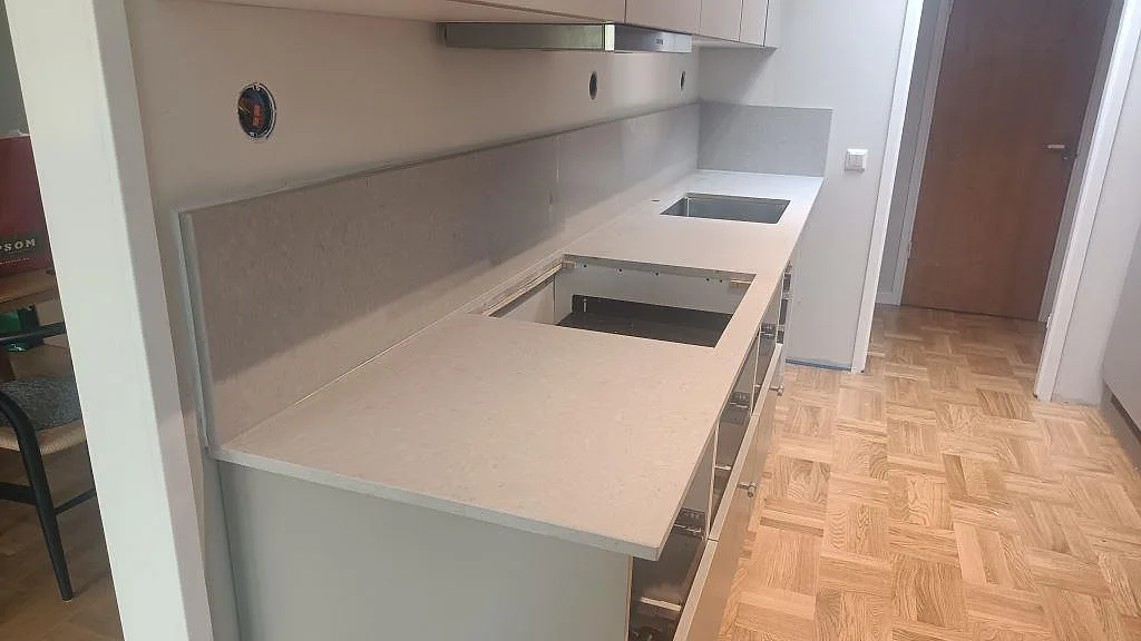 Köksbänkskiva i matt Caesarstone Clamshell, komposit, med hällöppning, diskho och uppvikt stänkkant i Mariestad.