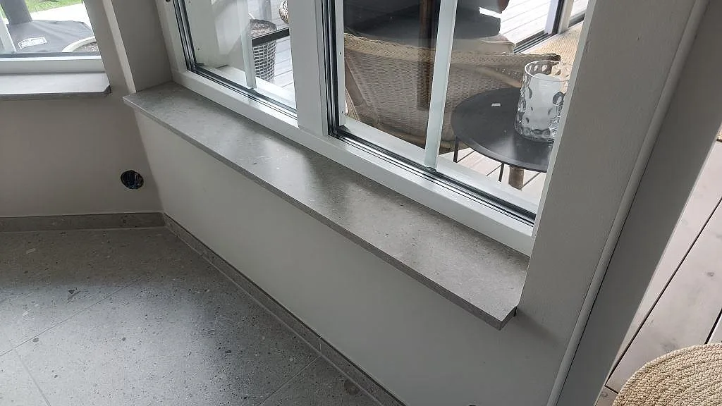 Fönsterbänk i matt Caesarstone Clamshell monterad under stora fönster i Södra Sandby.