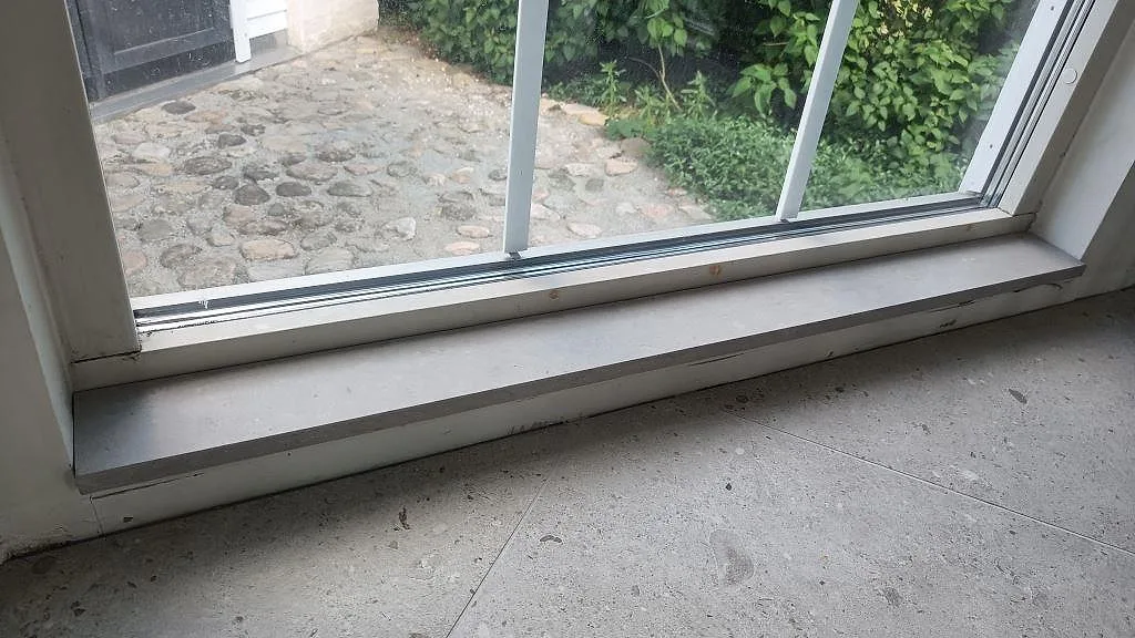Installerad fönsterbänk i matt Caesarstone Clamshell med ljus stenstruktur i Södra Sandby.