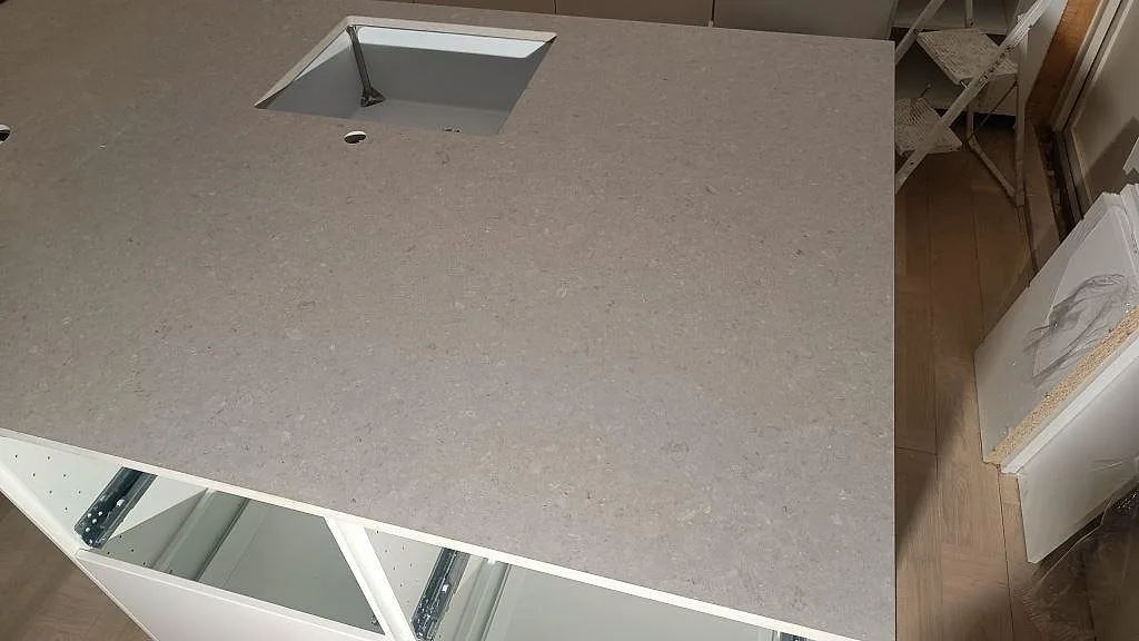 Köksarbetsyta i matt Caesarstone Clamshell-komposit på vita stommar, fotograferad under montering i Västra Frölunda.