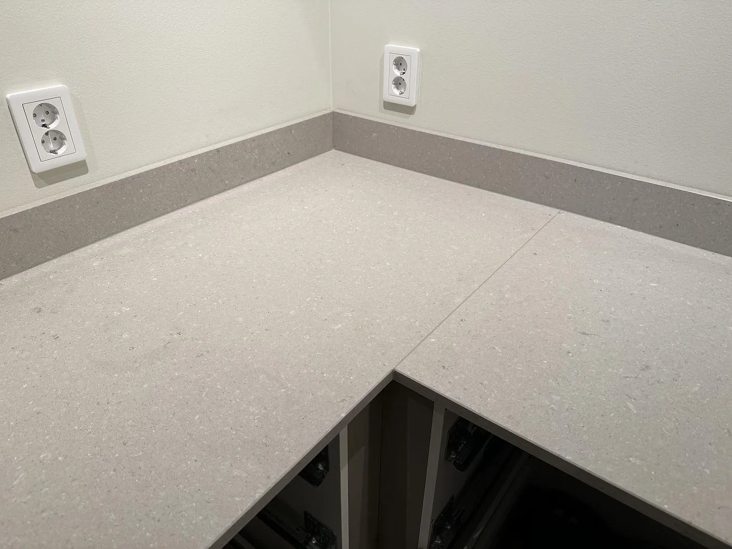 L-format hörn i polerad Caesarstone Clamshell köksbänkskiva med låg stänkkant och synlig fog i Veinge.