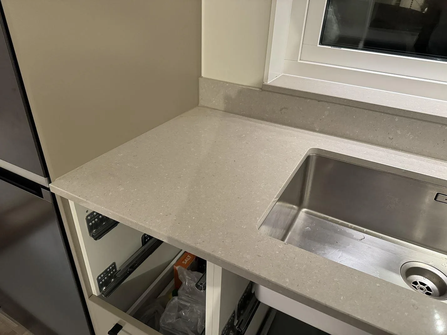 Polerad Caesarstone Clamshell köksbänkskiva med rostfri underlimmad diskho, fönster och låg stänkkant under montering i Veinge.