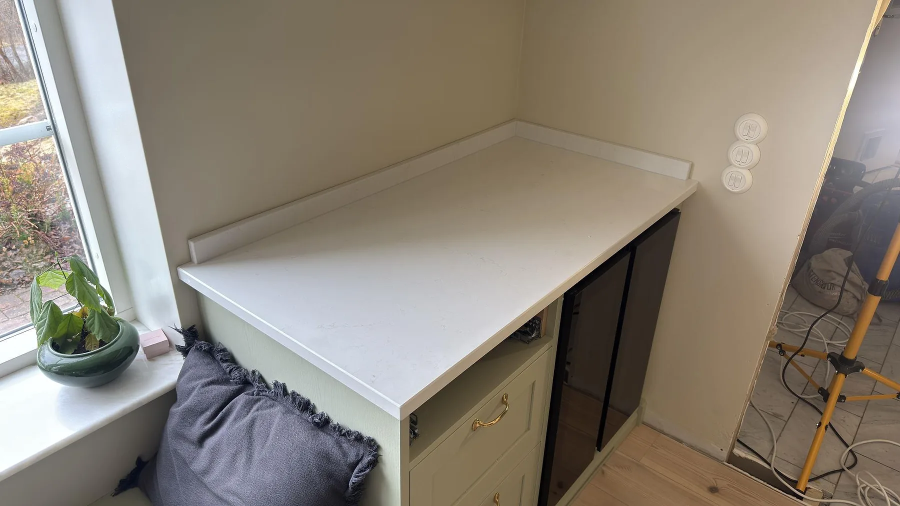 Vit kvartskompositskiva i Caesarstone Frosty Carrina monterad i en fönsternisch i ett kök i Vaxholm.