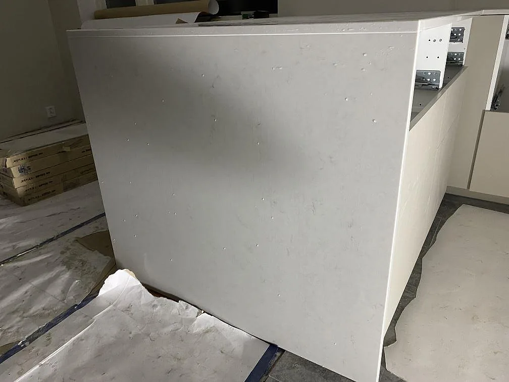 Lodrät gavel och arbetsyta i polerad Caesarstone London Grey-komposit på en kökshalvö under montering i Lund.