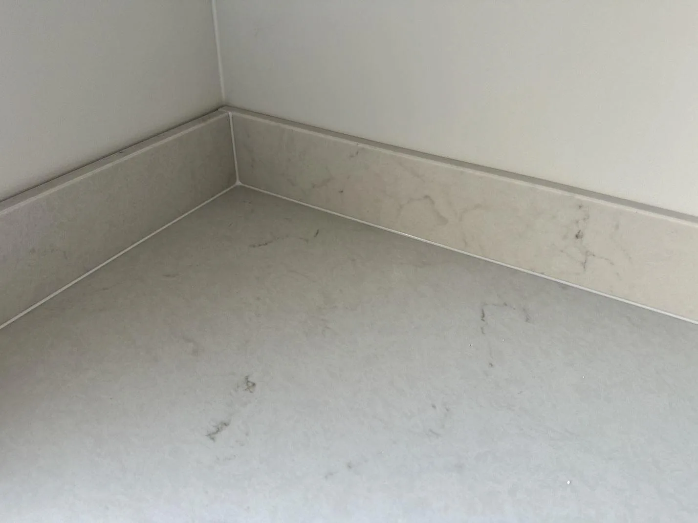 Närbild på hörn i Caesarstone London Grey med polerad komposityta, grå ådring och låg stänkkant i växjö.