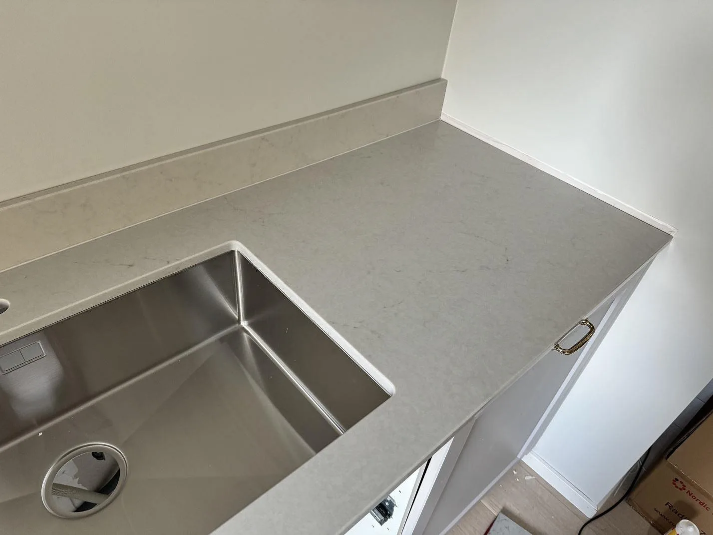 Polerad Caesarstone London Grey köksbänkskiva med rostfri diskho, ljus kompositsten och stänkkant i växjö.