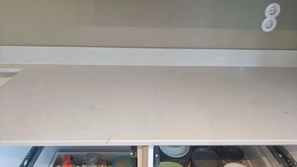 Närbild på den ljusgrå polerade ytan med diskret ådring på en Caesarstone London Grey bänkskiva i Varberg.