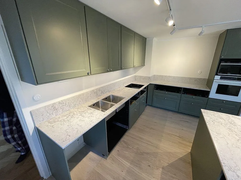Polerad Caesarstone Moorland Fog som köksbänkskiva med underlimmad rostfri dubbelho, hällöppning och stänkskydd i Borensberg.