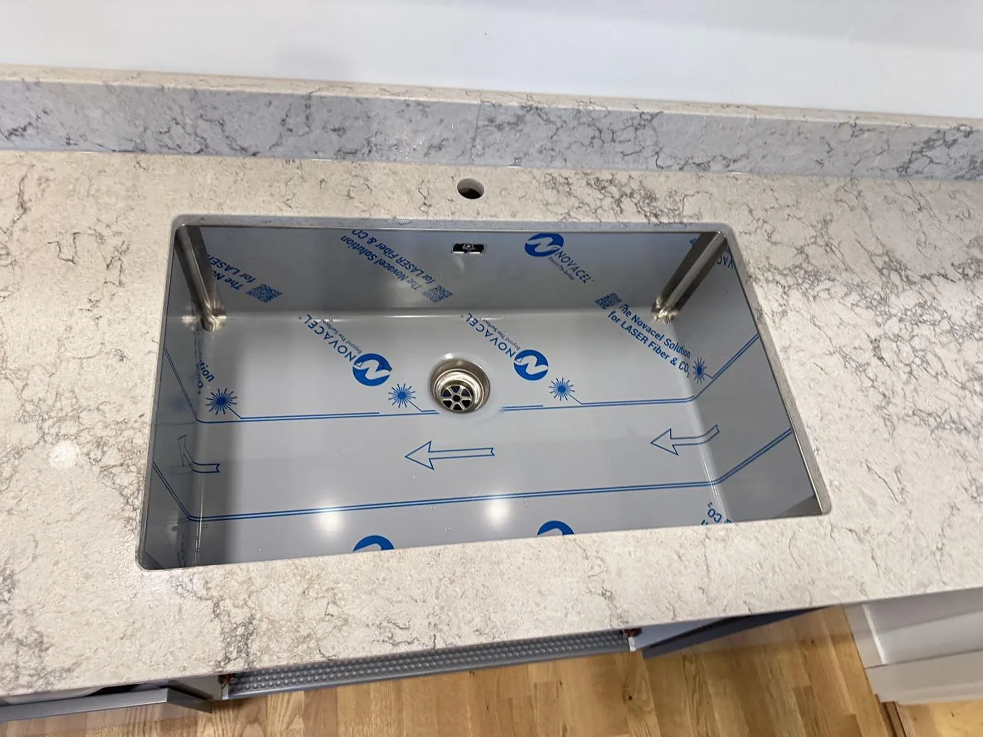 Ovanifrån på den underlimmade rostfria diskhon i köksbänkskivan i Caesarstone Moorland Fog i ett kök i Göteborg.