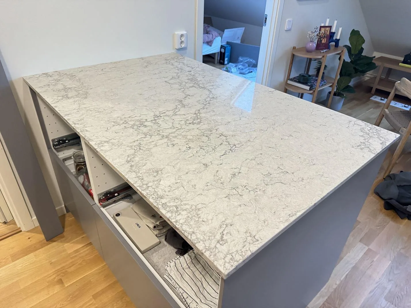 Köksbänkskivans ände i polerad Caesarstone Moorland Fog med grå ådring i ett kök i Göteborg.