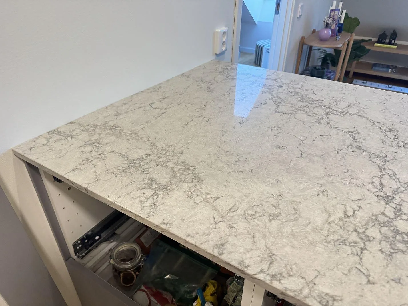 Närbild på den polerade ytan och den diskreta grå ådringen i Caesarstone Moorland Fog köksbänkskiva i ett kök i Göteborg.