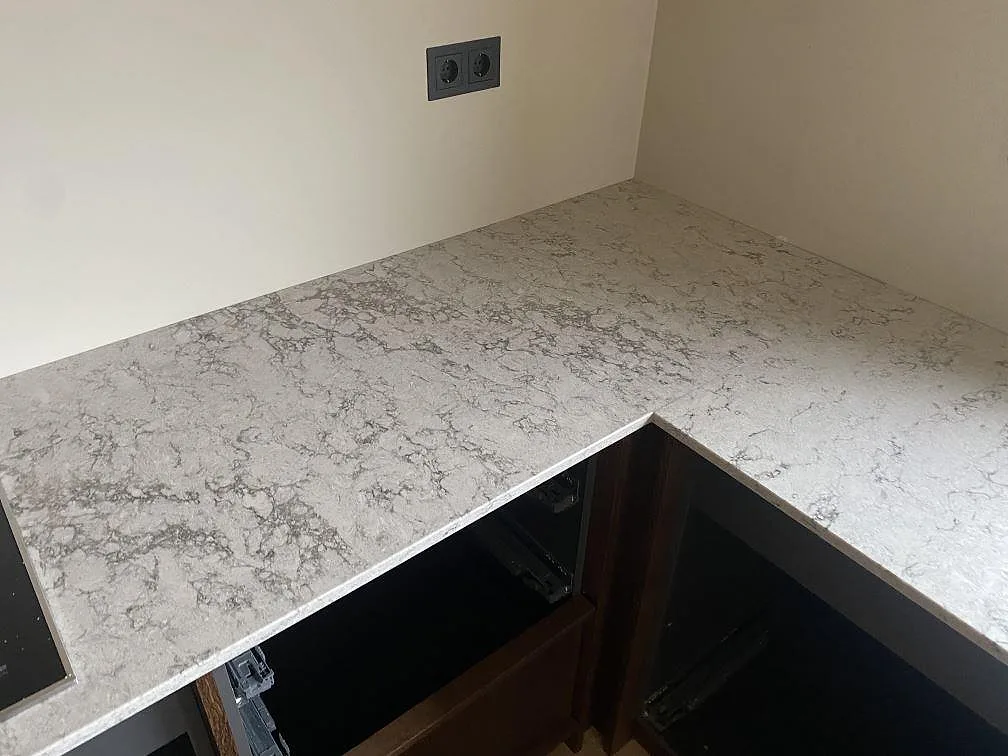 Hörndetalj av polerad köksbänkskiva i Caesarstone Moorland Fog i Grebbestad med mjukt grå spräcklig yta.
