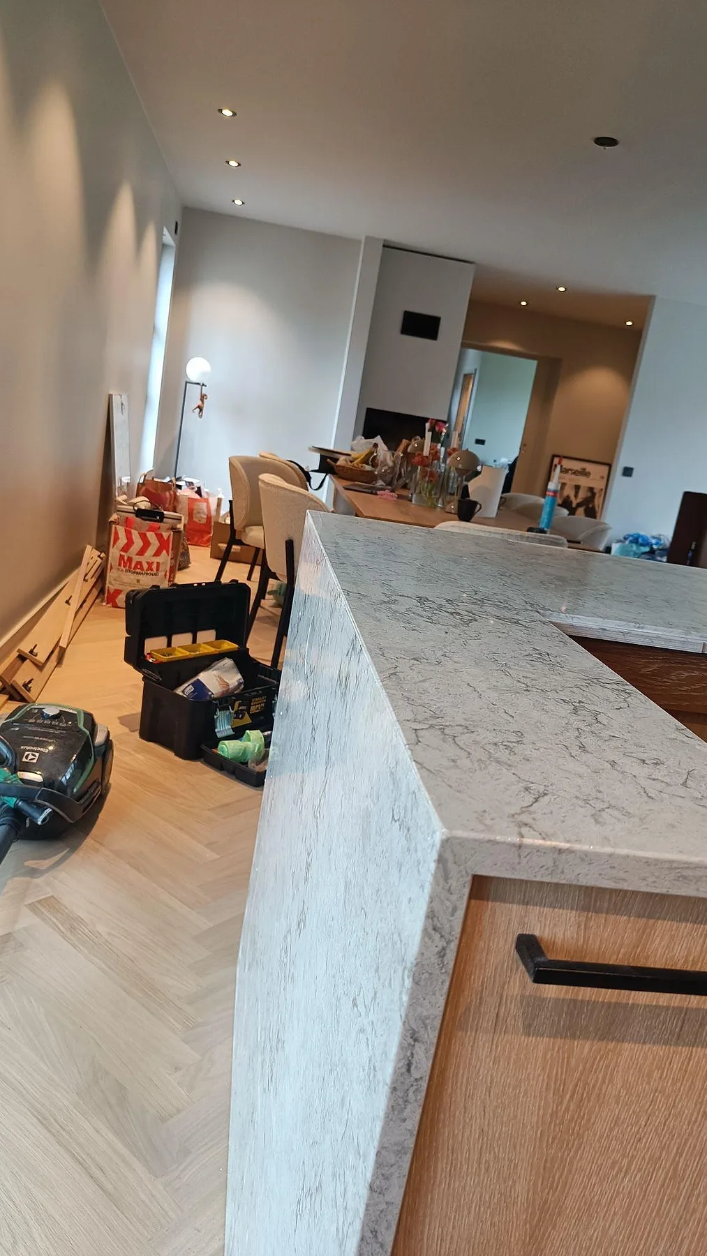 Sidovy av köksö i polerad Caesarstone Moorland Fog med vattenfallskant och träinredning i Höllviken.