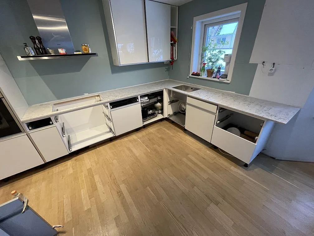 Köksbänkskivor i Caesarstone Moorland Fog längs två väggar i ett kök i Huddinge, fotograferat under monteringen.