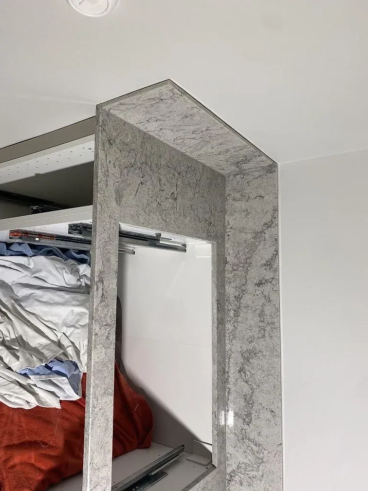 Uppvikt stänkkant och bänkyta i polerad Caesarstone Moorland Fog med grå ådring, i ett kök i Limhamn.