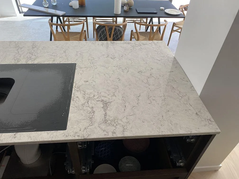 Närbild på höger sida av köksbänkskiva i Caesarstone Moorland Fog, polerad komposit, under montering i Lomma.