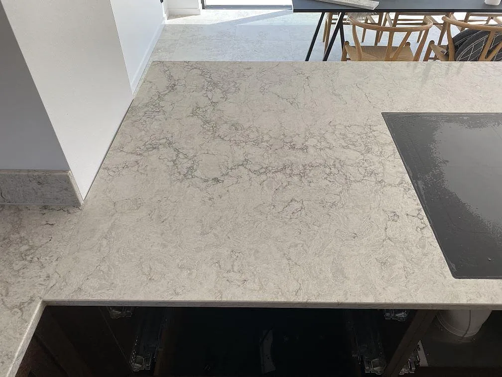 Närbild på ljusgrå köksbänkskiva i Caesarstone Moorland Fog, polerad komposit med diskret ådring i Lomma.