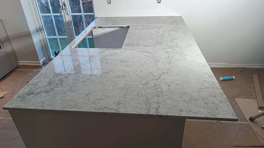 Stor köksö i Caesarstone Moorland Fog, polerad, med hälluttag och ljus grå ådring i ett kök i Malmö.
